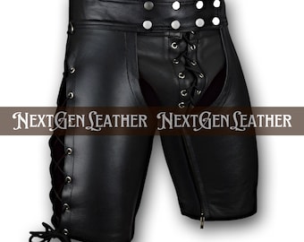 May include: Black leather chaps with lace-up sides and front. The chaps have a zipper on the right leg and silver-tone button details at the waist. The text "NEXTGEN LEATHER" is printed across the image.