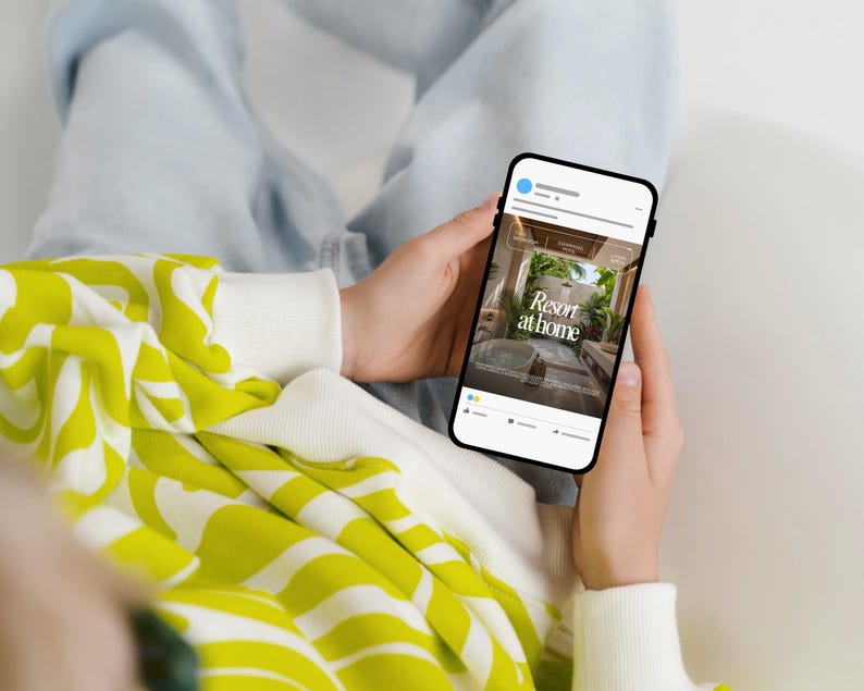 May include: A smartphone screen shows a social media post with the text "Resort at home." The phone is held by a person wearing a white and yellow patterned sweatshirt and light blue jeans. The phone screen displays an image of a luxurious outdoor space.