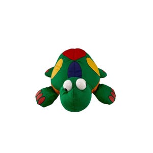 May include: A plush turtle toy with a green body, red and yellow accents, and large, googly eyes. The turtle's shell features a patchwork design. The toy is designed for children.