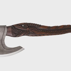 May include: A handcrafted axe with a dark wooden handle featuring intricate carvings of a mythical creature. The axe head is made of gray metal with a sharp, curved blade. A small, decorative gem is set into the handle.