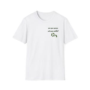 Peut inclure: T-shirt blanc avec l'inscription "are you gonna eat your pickle ?" en vert et trois illustrations de cornichons verts. Le t-shirt a des manches courtes et un col rond, id&eacute;al pour un look d&eacute;contract&eacute;.