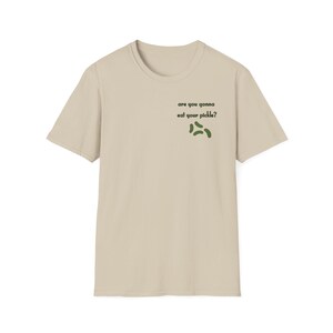 Peut inclure: T-shirt beige avec l'inscription "are you gonna eat your pickle ?" en noir et un motif de cornichons verts. Le t-shirt est &agrave; col rond et &agrave; manches courtes.