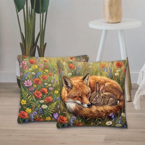 May include: Two decorative throw pillows with a nature theme. One pillow features a vibrant field of wildflowers. The other pillow depicts a sleeping fox and a rabbit nestled together in a field of flowers. The pillows have a soft, inviting appearance.