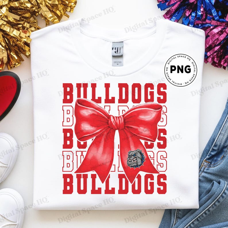 May include: White t-shirt featuring the word "BULLDOGS" in red, with a large red bow graphic and a bulldog head logo. The shirt is a crew neck style.