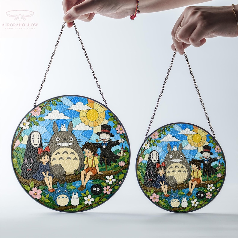 May include: Two round stained glass panels featuring a colorful scene with cartoon characters, a large gray creature, and a yellow sun. The panels are held by chains and have a black border. The background is a blue sky with white clouds.