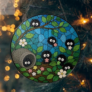 May include: Round stained glass window art featuring a whimsical forest scene. The design includes black, fluffy creatures with large eyes, green leaves, white flowers, and colorful star-shaped accents. The background is a mosaic of blue glass.