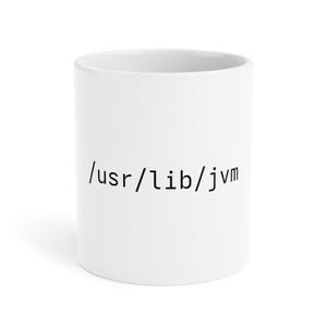 Peut inclure: Un mug en céramique blanche avec le texte noir /usr/lib/jvm imprimé dans une police à chasse fixe sur le devant. Le mug présente une forme cylindrique avec une finition lisse et un design simple et épuré mettant en valeur le chemin d'accès.