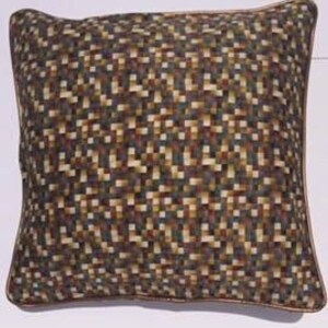 May include: Square decorative pillow with a pixelated pattern in shades of brown, tan, and green. The pillow has a brown border and a soft, textured appearance. The pillow is designed for home decor.