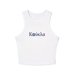 Op de afbeelding: Witte mouwloze crop top met het Griekse woord "Κούκλα" in blauw schrift. Het woord heeft een boze oogsymbool in plaats van de letter "o". De top heeft een ronde halslijn en is gemaakt van een zacht materiaal.