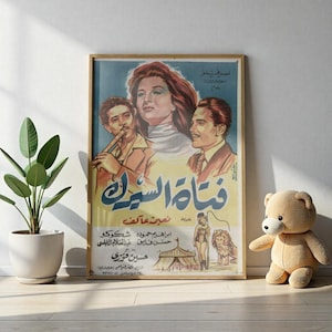 May include: Framed vintage movie poster with Arabic text and illustrations. The poster features three people, a woman with red hair, and two men. The bottom of the poster shows a circus scene with a lion and a performer.