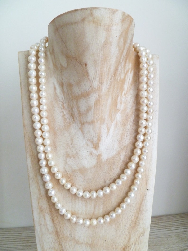 Ivory, white pearls round shape, lovely lustre. with a silver lobster clasp closure. Shown are 2 sets of pearl necklaces of differing sizes.