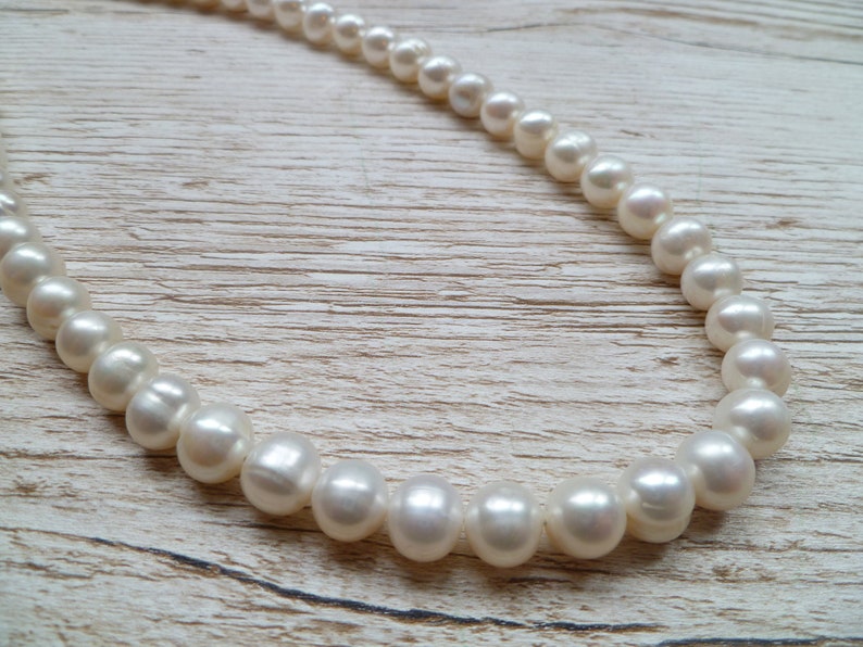 Ivory, white pearls round shape, lovely lustre. with a silver lobster clasp closure.