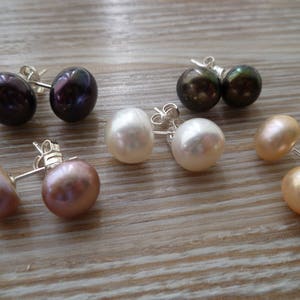 Picture shows five pairs of circular, pearl stud earrings, with silver post and scroll back/butterfly fixings. Colours shown are: ivory, peach, peacock blue and pink.