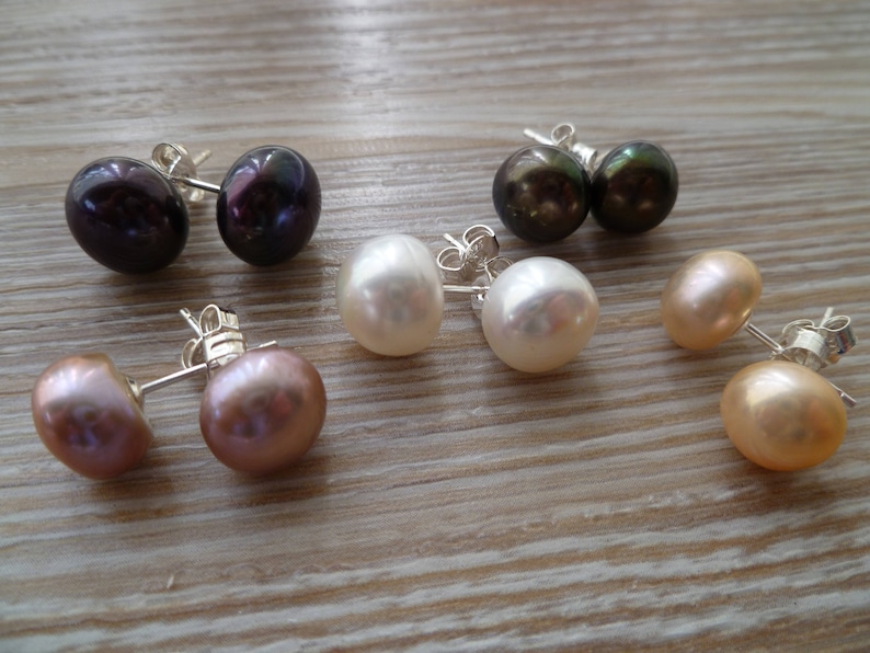 Picture shows five pairs of circular, pearl stud earrings, with silver post and scroll back/butterfly fixings. Colours shown are: ivory, peach, peacock blue and pink.