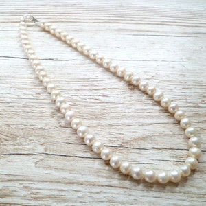 Ivory, white pearls round shape, lovely lustre. with a silver lobster clasp closure.