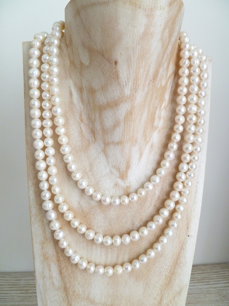 Ivory, white pearls round shape, lovely lustre. with a silver lobster clasp closure. Shown are 3 sets of pearl necklaces of differing sizes.