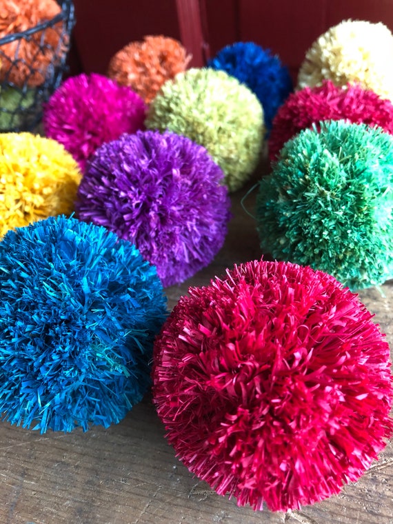 A series of small, abstract sculptures made from colorful pom poms and various craft materials, showcasing creative solutions for using imperfect pom poms.