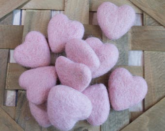 May include: A group of pink felt hearts in a basket. The hearts are all different sizes and shapes.