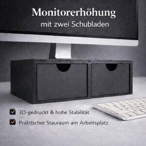 Könnte beinhalten: Schwarzer Monitorständer aus Holz mit zwei Schubladen. Der Ständer hat einen gebogenen Griff an jeder Schublade. Der Text auf dem Bild lautet "Monitorerhöhung mit zwei Schubladen". Eine weiße Tastatur ist im Vordergrund zu sehen.