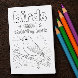 May include: A white "Birds mini Coloring book" with a bird illustration, clouds, and hearts. Five coloured pencils in blue, green, orange, and purple are next to the book. The book and pencils are on a dark brown wooden surface.