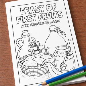 Może przedstawiać: Mini kolorowanka z napisem FEAST OF FIRST FRUITS z czarno-białą ilustracją koszyka z chlebem, słoika miodu z nabierakiem oraz dwóch butelek. Niebieska i zielona kredka leżą na dolnej części okładki.