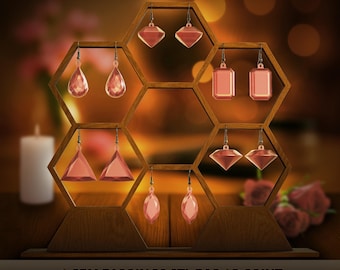 May include: A wooden display stand with a honeycomb design holds six pairs of pink gem earrings. The earrings have various geometric shapes, including teardrops, diamonds, and rectangles. The text at the bottom reads "6 GEM EARRINGS STL FOR 3D PRINT".