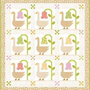 May include: A patchwork quilt featuring a repeating pattern of geese and flowers. The geese are tan with orange beaks and feet, and the flowers are pink, green, and yellow. The quilt has a floral border and a white background.