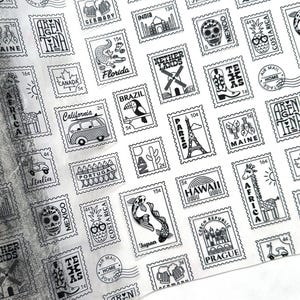 May include: Black and white patterned paper with postage stamp designs. Stamps feature illustrations of landmarks, animals, and country names like Japan, Hawaii, and California. A roll of the paper is visible on the left.