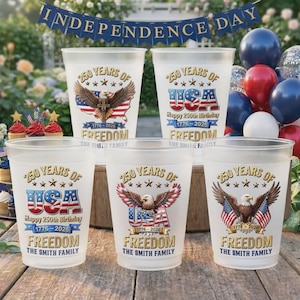 Könnte beinhalten: Eine Sammlung von mattierten Plastikbechern mit patriotischen Designs. Jeder Becher zeigt den Text "250 Years of USA" mit einem Adler, der amerikanischen Flagge und den Worten "Freedom" und "The Smith Family". Die Becher sind zum Unabhängigkeitstag.