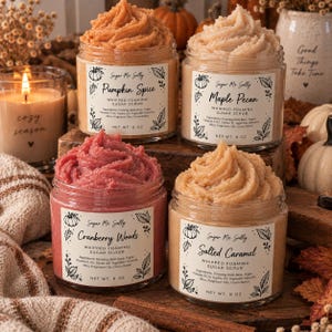May include: Four clear jars of whipped foaming sugar scrub by Sugar Me Sally, each 8 oz. Scents include Pumpkin Spice, Maple Pecan, Cranberry Woods, and Salted Caramel. Each jar features a white label with botanical illustrations and ingredient lists.
