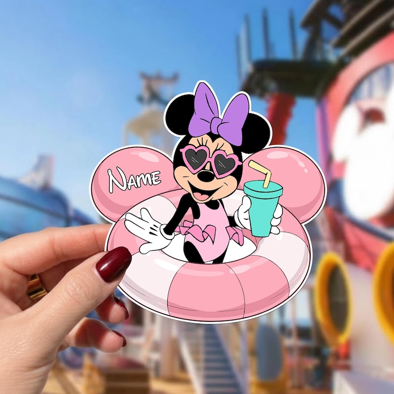 May include: A Minnie Mouse sticker in a pink and white inner tube, wearing heart-shaped sunglasses and a purple bow. She holds a turquoise drink with a yellow straw. The sticker has a pink balloon with the word "Name" on it.