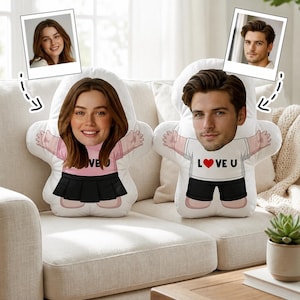 May include: Two custom-shaped plush cushions featuring printed photographic faces of a person. The left cushion shows a person in a pink shirt and black skirt. The right cushion shows a person in a white shirt with the text LOVE U and a red heart.