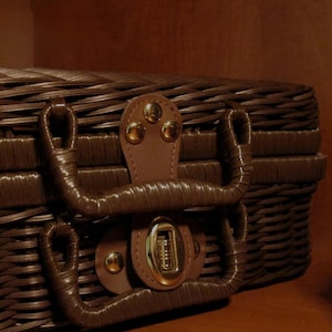 Peut inclure: Un panier de pique-nique en osier marron avec une poign&eacute;e et un fermoir en cuir. Le panier a un design tiss&eacute; et un loquet s&eacute;curis&eacute;. La poign&eacute;e est fix&eacute;e avec des rivets dor&eacute;s. Le panier est con&ccedil;u pour transporter de la nourriture et des boissons.