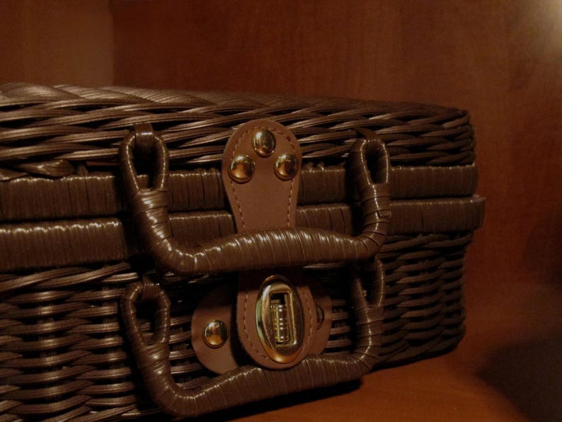 Peut inclure: Un panier de pique-nique en osier marron avec une poign&eacute;e et un fermoir en cuir. Le panier a un design tiss&eacute; et un loquet s&eacute;curis&eacute;. La poign&eacute;e est fix&eacute;e avec des rivets dor&eacute;s. Le panier est con&ccedil;u pour transporter de la nourriture et des boissons.