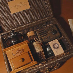 Peut inclure: Un coffret cadeau en osier marron contenant un moulin &agrave; caf&eacute;, une bo&icirc;te &agrave; caf&eacute; en bois, une petite radio, un bocal de grains de caf&eacute; et une petite carte. L'ensemble comprend une &eacute;tiquette cadeau avec l'inscription "a gift for you".