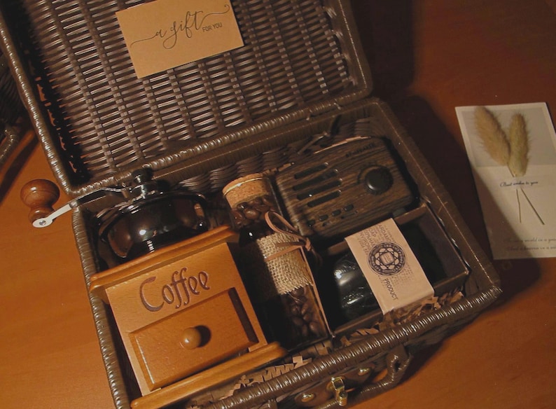 Peut inclure: Un coffret cadeau en osier marron contenant un moulin &agrave; caf&eacute;, une bo&icirc;te &agrave; caf&eacute; en bois, une petite radio, un bocal de grains de caf&eacute; et une petite carte. L'ensemble comprend une &eacute;tiquette cadeau avec l'inscription "a gift for you".