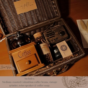 Peut inclure: Un panier cadeau en osier marron rempli d'articles sur le th&egrave;me du caf&eacute;. Comprend un moulin &agrave; caf&eacute; en bois, une bouteille de grains de caf&eacute;, un haut-parleur r&eacute;tro et du savon au caf&eacute;. Une petite carte dit "a gift for you."