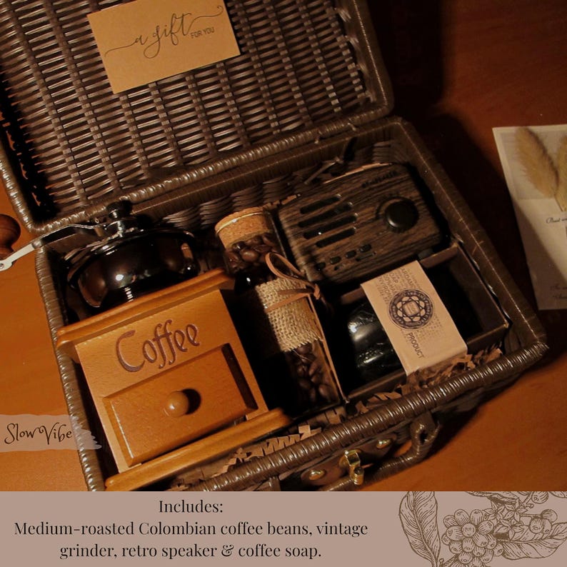 Peut inclure: Un panier cadeau en osier marron rempli d'articles sur le th&egrave;me du caf&eacute;. Comprend un moulin &agrave; caf&eacute; en bois, une bouteille de grains de caf&eacute;, un haut-parleur r&eacute;tro et du savon au caf&eacute;. Une petite carte dit "a gift for you."