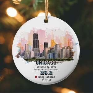May include: White ceramic ornament with a Chicago skyline design. The ornament features a watercolor-style cityscape with the text "CHICAGO", "OCTOBER 12, 2025", "Marathon Finisher", "26.2", a heart symbol, a name, and a time.