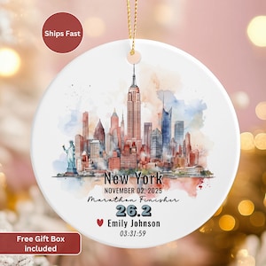 May include: A white ceramic Christmas ornament featuring a watercolor depiction of the New York City skyline. The ornament includes the text "New York," "Marathon Finisher," and the date November 02, 2025. It also displays the name "Emily Johnson" and a marathon time.