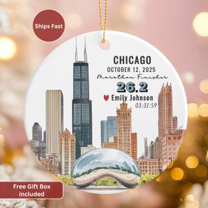 May include: A round, white ceramic ornament with a gold string for hanging. The ornament features a watercolor illustration of the Chicago skyline, with text that reads "CHICAGO OCTOBER 12, 2025 Marathon Finisher 26.2 Emily Johnson 03:31:59."