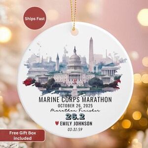 May include: White ceramic ornament with a watercolor depiction of Washington D.C. landmarks. The text reads "MARINE CORPS MARATHON OCTOBER 26, 2025 Marathon Finisher 26.2 EMILY JOHNSON 03:31:59". Includes a gold string for hanging.