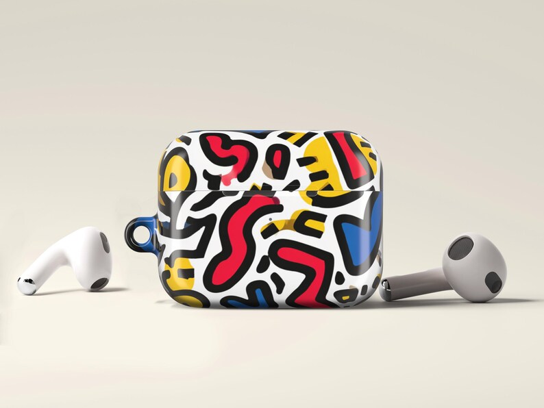May include: Wireless earbuds and a case with a vibrant abstract design. The case has a pattern of red, yellow, blue, and black shapes on a white background. The earbuds are positioned near the case, showcasing a modern aesthetic.