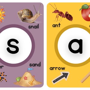 以下が含まれることがあります： 「S」と「A」の文字が書かれた教育用フラッシュカード。「S」のカードには太陽、カタツムリ、クモ、砂のお城が描かれています。「A」のカードにはアリ、リンゴ、矢、斧が描かれています。各カードには、白い円の中に大きな文字が書かれています。