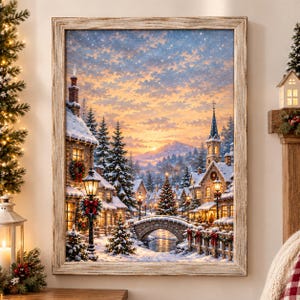 May include: A framed wall art print depicting a snowy winter village scene at sunset. The image features stone houses, snow-covered pine trees, a stone bridge over a stream, and a church steeple under a golden sky with falling snow.