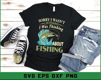 May include: Black t-shirt with the text "Sorry I Wasn't Listening I Was Thinking About Fishing" and a graphic of a fish jumping out of water. The shirt is paired with blue jeans and black sneakers.