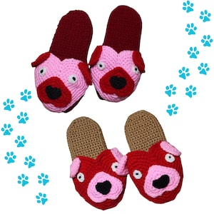 May include: Four handmade crochet slippers in the shape of pug dogs. Two pairs of slippers are visible. One pair is pink and burgundy, and the other is red and tan. The slippers have white eyes and black noses. Blue paw prints are in the background.
