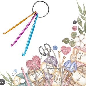 May include: A collection of three colorful crochet hooks attached to a silver ring. The hooks are gold, purple, and blue. The image also includes a wire basket filled with yarn, a bunny, and other craft supplies.