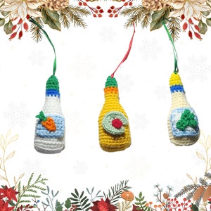 May include: Three crocheted ornaments shaped like bottles of condiments. The bottles are decorated with green, yellow, and white yarn. One bottle has a carrot, another has a green leaf, and the third has a green sprig.