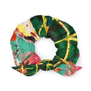 May include: A green, yellow, red, and pink patterned scrunchie with a knotted bow.